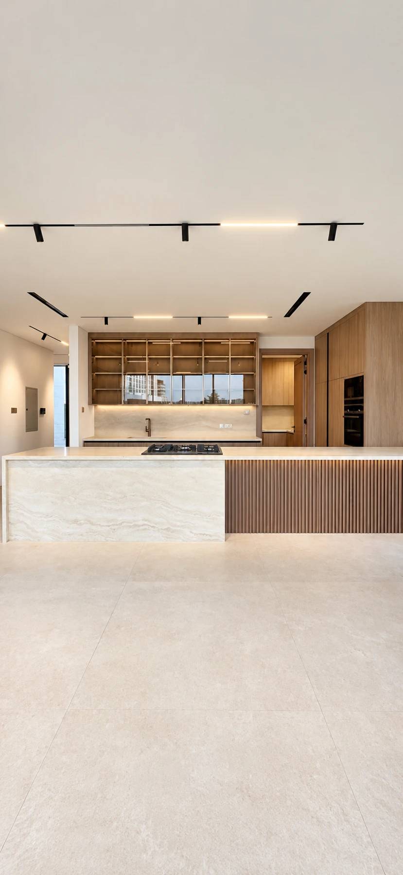 Straight-on view of the kitchen island and illuminated cabinetry